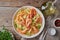 Shrimp, pasta tagliatelle, green peas, dill. White plate on old rustic wooden table, top view, copy space