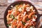 Shrimp saganaki with tomato and feta cheese close-up. Horizontal