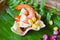 Shrimp salad corn and sauce on prawn crackers with banana leaf background asian food in thai - delicious menu shrimp prawn cooked