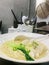 Shrimp wonton and noodle soup in white bowl. Vertical photo image.
