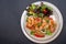 Shrimpand salad of fresh vegetables close-up on a plate on black background. horizontal view from above