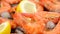 Shrimps with lemon and ice cubes rotating closeup