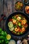 Shrimps, rice noodles, broccoli and shimeji mushrooms on wooden table