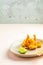 Shrimps tempura in light plate on pink or peach concrete surface