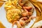 Shrimps on white dish over wood table, served with rise and french fries, top view. Seafood concept.Selective focus.