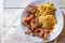 Shrimps on white dish over wood table, served with rise and french fries, top view. Seafood concept.Selective focus.