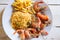 Shrimps on white dish over wood table, served with rise and french fries, top view. Seafood concept.Selective focus.