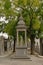 Shrine with statue of a kneeling women in a lane with grave tombs