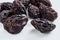 Shriveled and cracked prunes on a light gray background