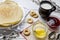 Shrovetide festival. Russian pancakes with raspberry jam, honey and sushki on white wooden background