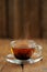 Shu puerh tea brewed steaming in glass cup on wooden background