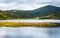 Shudu lake a 3705m high plateau lake view with forest and mountains in distance in Potatso national park Shangri-La Yunnan China