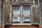 Shuttered window with locks and gray barn wood siding