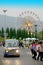 Shuttle bus with colorful ferris wheel background.