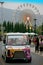 Shuttle bus with colorful ferris wheel background.