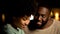 Shy afro-american couple on night date, tender feelings, trust and closeness