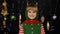 Shy shamed child girl in Christmas elf Santa helper costume posing looking camera and smiling