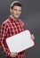 Shy young man holding a blank display to present