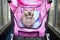 a siamese cat lounging in a pink baby stroller