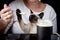 Siamese cat in a woman`s arms is eating sour cream from a spoon