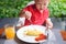 Sian 2 years old toddler baby boy child wearing red shirt use Fork and Knife eating breakfast in garden