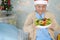 Sian senior or elderly old lady woman patient with Santa Claus helper hat holding salad vegetable healthy food in christmas