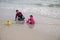 Sianoukville, Cambodia - 4 April 2018: woman and child play in sand of beach. Marine landscape with mother and child