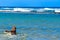 Siberian Husky puppy swimming on the shore sea splashing water