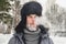 Siberian Russian man with a beard in hoarfrost in freezing cold in the winter freezes and wears a hat with a earflap