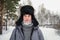 Siberian Russian man with a beard in hoarfrost in freezing cold in the winter freezes and wears a hat with a earflap