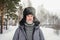 Siberian Russian man with a beard in hoarfrost in freezing cold in the winter freezes and wears a hat with a earflap