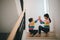 Sibling Asian girls playing rock paper scissors hand game. children sitting on stairs at home playing together