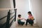 Sibling Asian girls playing rock paper scissors hand game. children sitting on stairs at home playing together