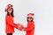 Sibling Asian girls in red Santa hat with gift boxes on white background