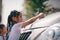 Sibling Asian girls wash their cars and have fun playing indoors on a hot summer day