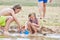 Sibling children build a sandcastle