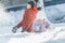 Sibling children making snowstorm by tossing up snow during frosty winter sunny day outdoors