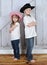 Sibling cowboy and cowgirl in sweet pose