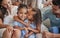 Sibling love, family and kiss with children sharing a special sister bond while at home with mom and dad for bonding and