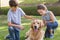 Sibling with their dog in the park