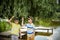 Siblings, brother, hugs. Two children, older boy and his younger brother standing on the shore of the lake near old tree.