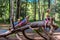 Siblings climbing on a big log in a forest