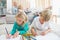 Siblings colouring and drawing on the floor