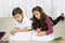 These siblings do everything together. a cute little boy and his sister colouring in together at home.