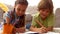 Siblings drawing pictures on the floor