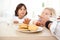 Siblings eating biscuits and drinking milk