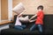 Siblings having pillow fight on a couch confined at home during self-isolation