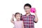 Siblings holding coin and piggybank over white