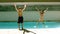 Siblings jumping together in the swimming pool