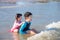 Siblings laughing happily after being hit by the sea